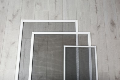 Set of window screens on wooden floor, flat lay Photo of Set of window screens on wooden floor, flat lay