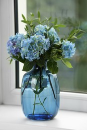 Beautiful blue hortensia flowers in vase on window sill indoors Photo of Beautiful blue hortensia flowers in vase on window sill indoors