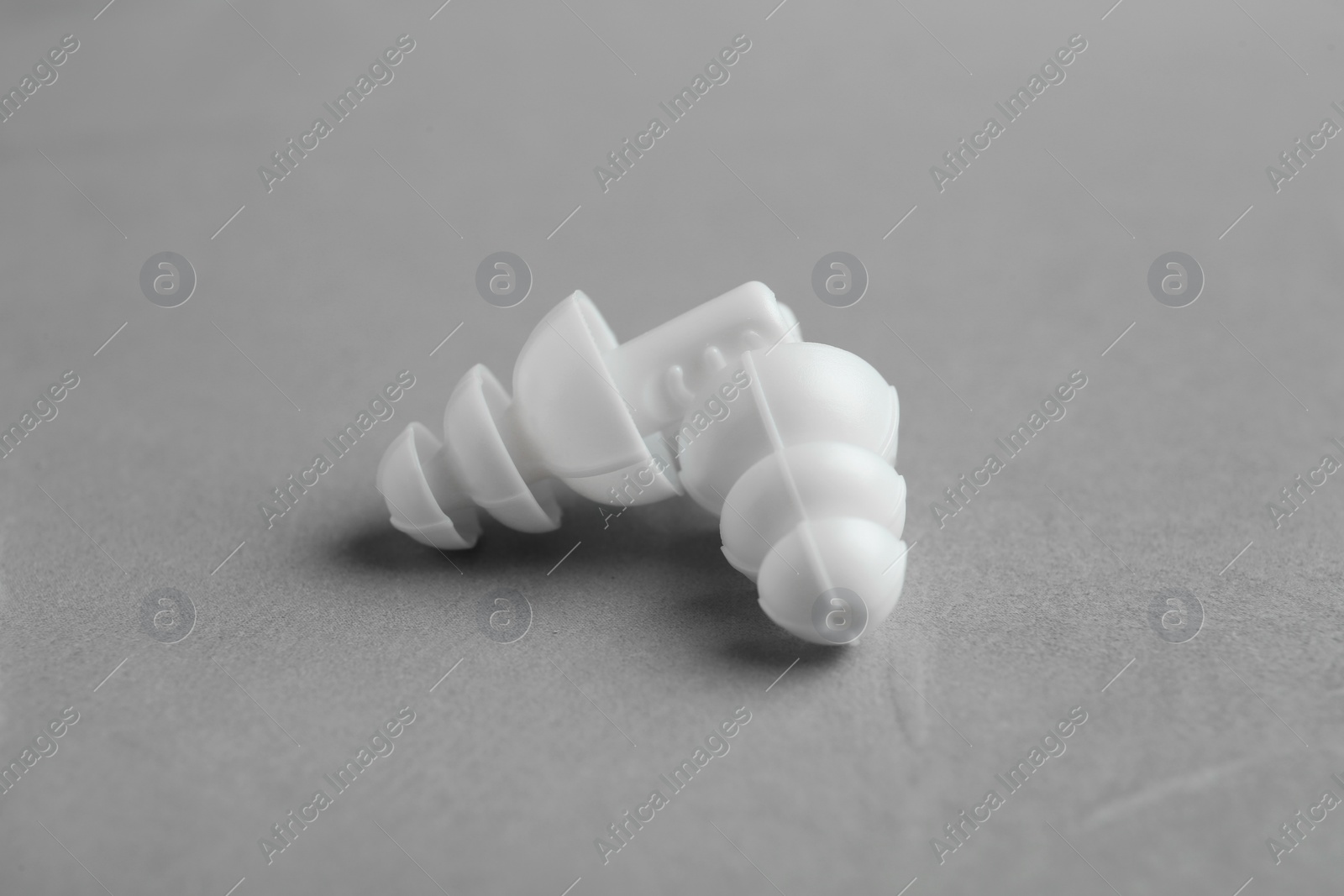 Pair of white ear plugs on grey background, closeup Photo of Pair of white ear plugs on grey background, closeup