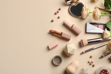 Flat lay composition with makeup products and beautiful roses on beige background, space for text Photo of Flat lay composition with makeup products and beautiful roses on beige background, space for text