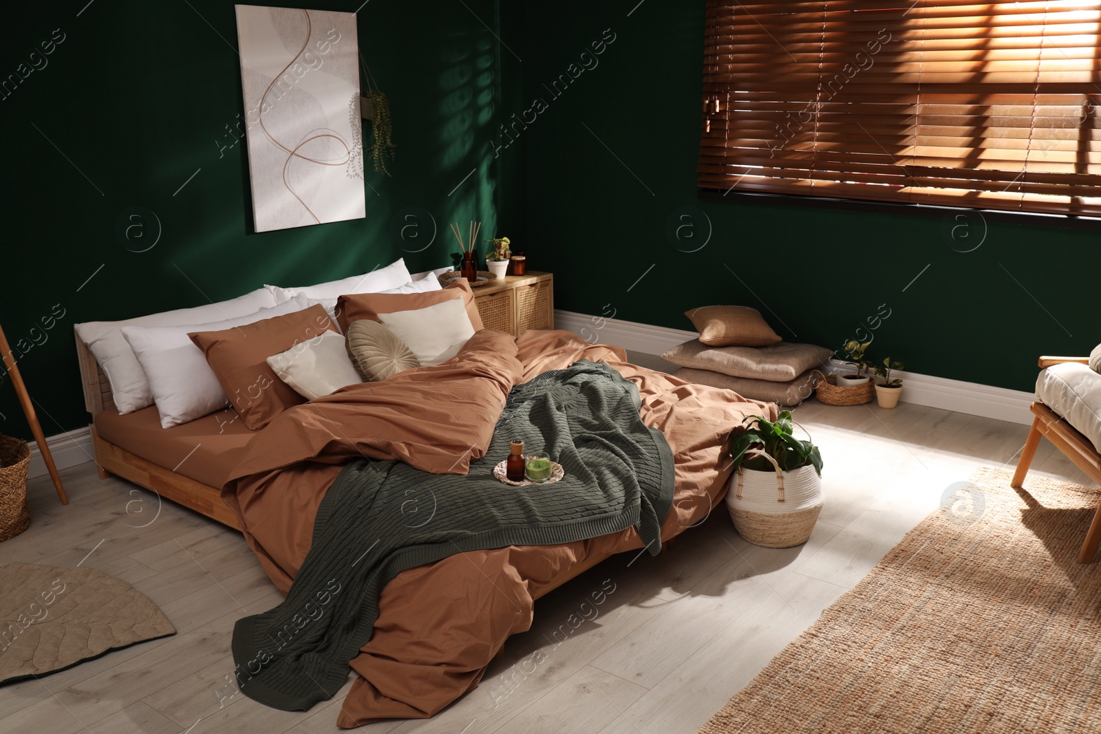 Stylish interior with large comfortable bed and potted plants Photo of Stylish interior with large comfortable bed and potted plants