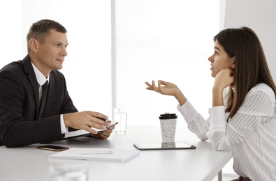 Office employees talking at table during meeting Photo of Office employees talking at table during meeting