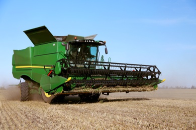 Modern combine harvester working in agricultural field Photo of Modern combine harvester working in agricultural field