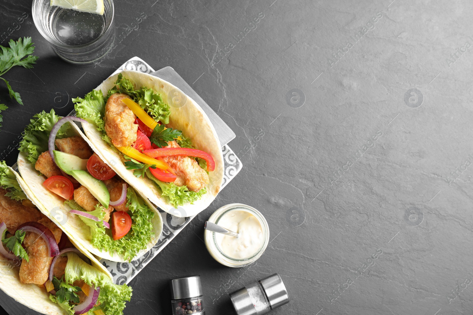 Delicious fish tacos served on grey table, flat lay with space for text Photo of Delicious fish tacos served on grey table, flat lay with space for text