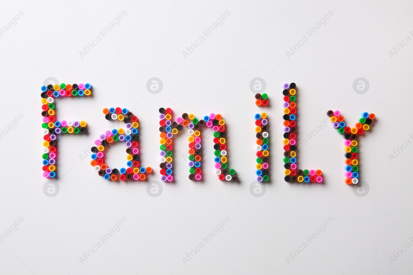 Word Family made of melty beads on white background, flat lay Photo of Word Family made of melty beads on white background, flat lay