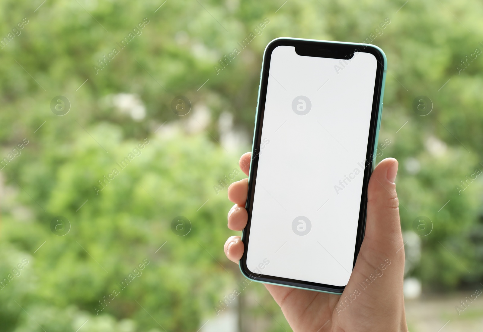 Photo of MYKOLAIV, UKRAINE - JULY 8, 2020: Woman holding Iphone 11 Pro Max with blank screen outdoors, closeup