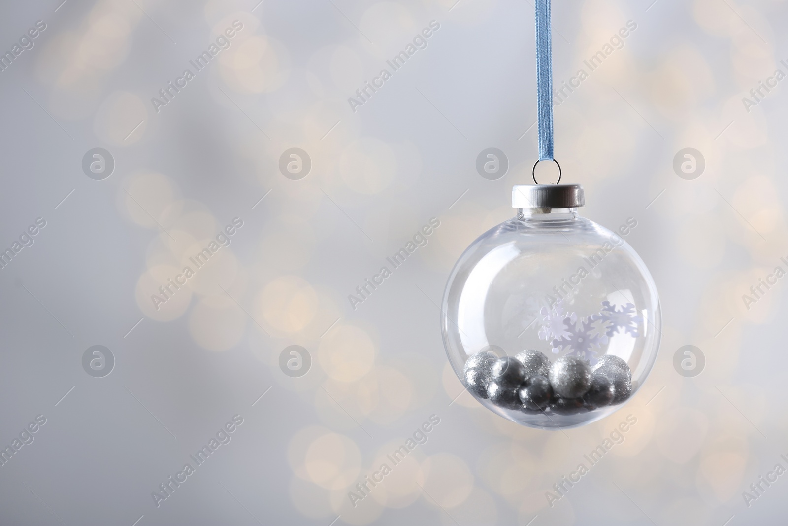 Decorative snow globe against blurred festive lights, space for text Photo of Decorative snow globe against blurred festive lights, space for text