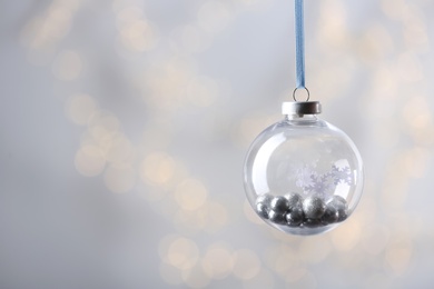 Decorative snow globe against blurred festive lights, space for text Photo of Decorative snow globe against blurred festive lights, space for text
