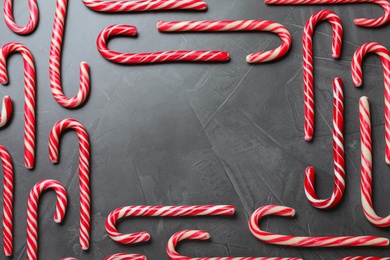 Frame of sweet Christmas candy canes on grey background, flat lay. Space for text Photo of Frame of sweet Christmas candy canes on grey background, flat lay. Space for text