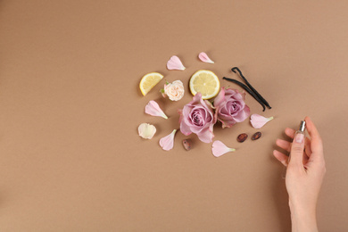 Woman with perfume. Fragrance composition, flowers and lemon on light brown background, top view Photo of Woman with perfume. Fragrance composition, flowers and lemon on light brown background, top view