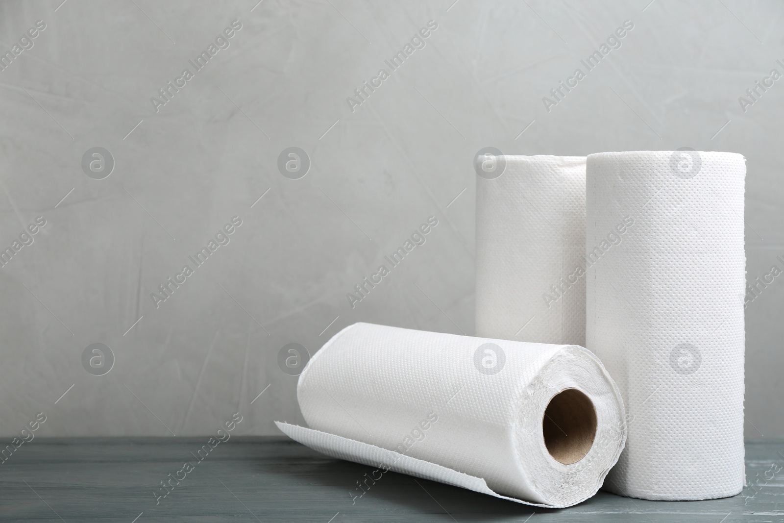Rolls of paper towels on grey wooden table, space for text Photo of Rolls of paper towels on grey wooden table, space for text