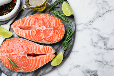 Top view of fresh raw salmon and products on white marble table. Fish delicacy Photo of Top view of fresh raw salmon and products on white marble table. Fish delicacy