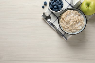 Tasty oatmeal porridge served on light wooden table, flat lay. Space for text Photo of Tasty oatmeal porridge served on light wooden table, flat lay. Space for text