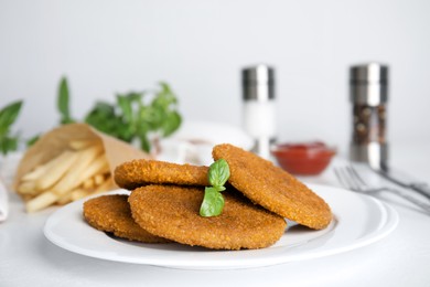 Delicious fried breaded cutlets served on white table, closeup Photo of Delicious fried breaded cutlets served on white table, closeup