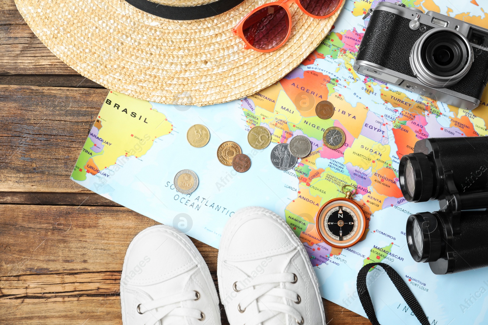 Flat lay composition with world map and different travel accessories on wooden table. Planning summer vacation trip Photo of Flat lay composition with world map and different travel accessories on wooden table. Planning summer vacation trip