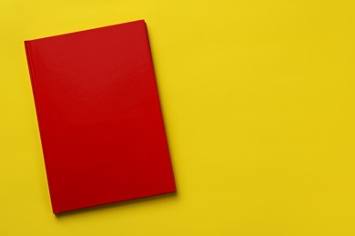 New stylish planner with hard cover on yellow background, top view. Space for text Photo of New stylish planner with hard cover on yellow background, top view. Space for text