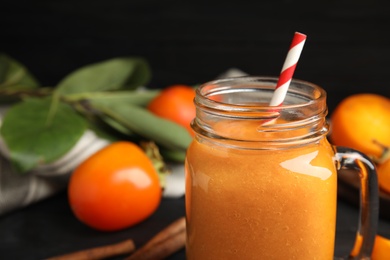 Tasty persimmon smoothie with straw in mason jar, closeup. Space for text Photo of Tasty persimmon smoothie with straw in mason jar, closeup. Space for text