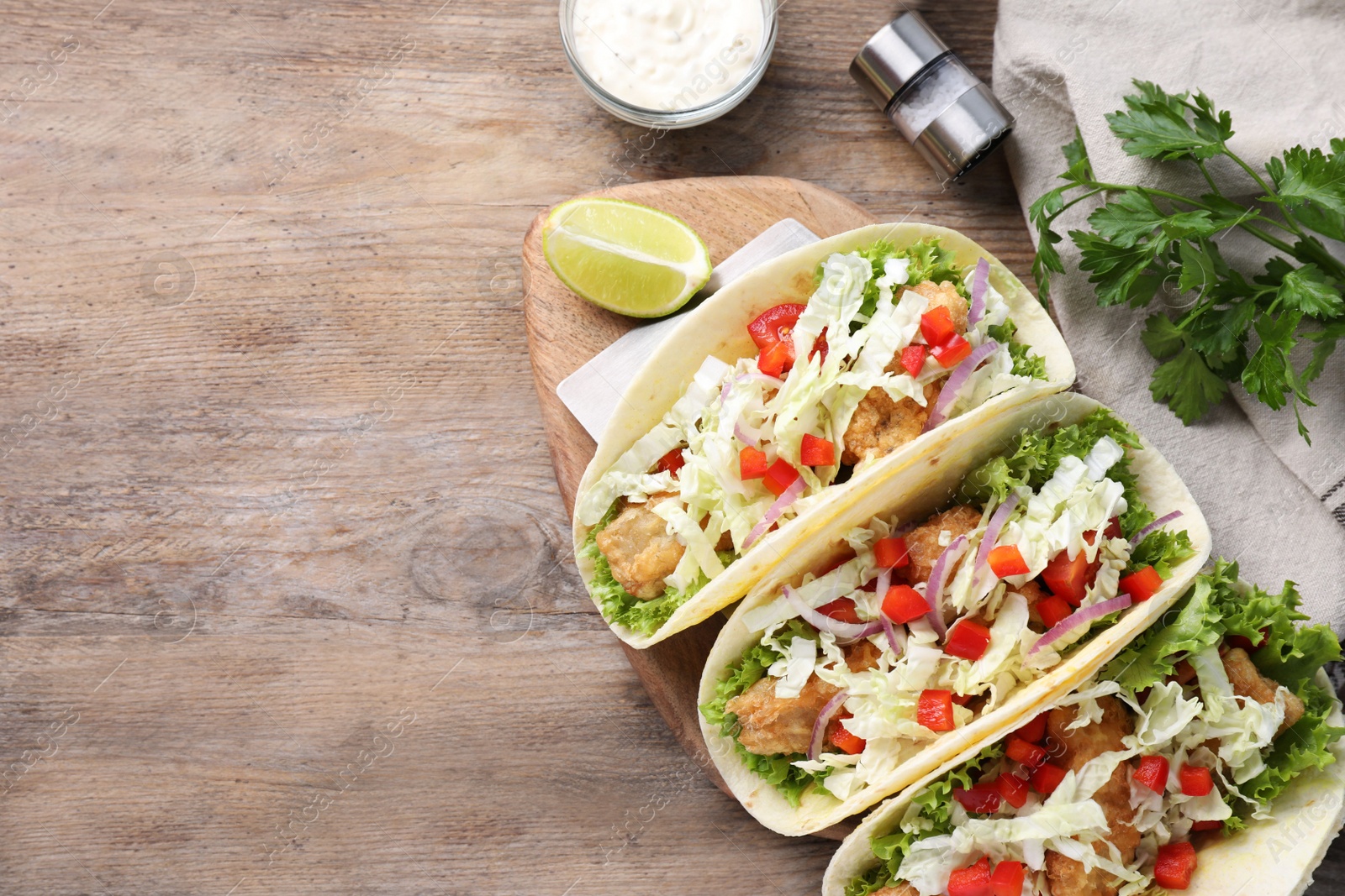 Yummy fish tacos served on wooden table, flat lay. Space for text Photo of Yummy fish tacos served on wooden table, flat lay. Space for text