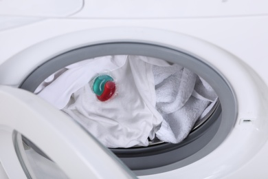 Photo of Laundry detergent capsule in washing machine drum, closeup view