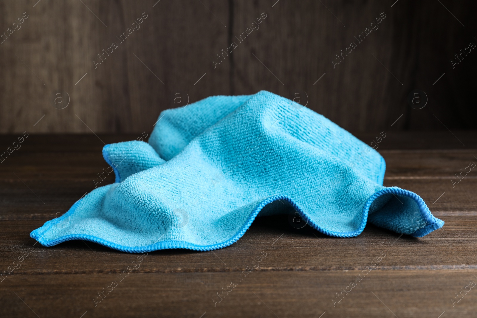 Light blue microfiber cloth on wooden table, closeup Photo of Light blue microfiber cloth on wooden table, closeup