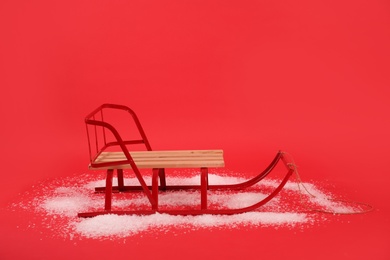 Empty sleigh and snow on red background Photo of Empty sleigh and snow on red background