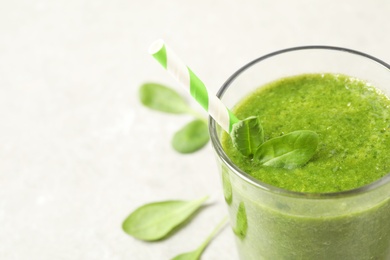Green juice and fresh spinach leaves on light grey table, closeup. Space for text Photo of Green juice and fresh spinach leaves on light grey table, closeup. Space for text