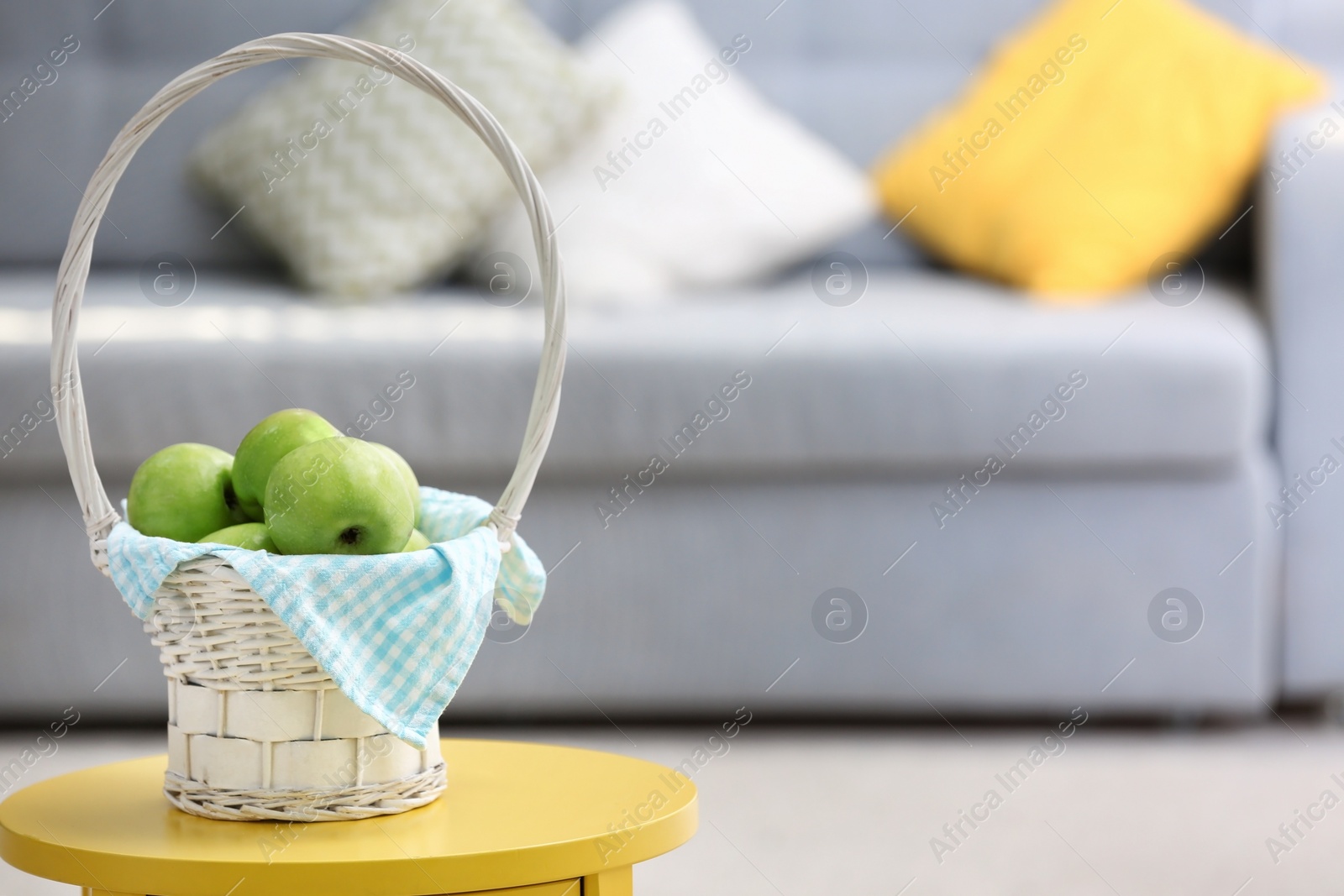 Basket with ripe green apples on table indoors Photo of Basket with ripe green apples on table indoors