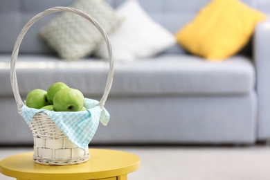 Basket with ripe green apples on table indoors Photo of Basket with ripe green apples on table indoors