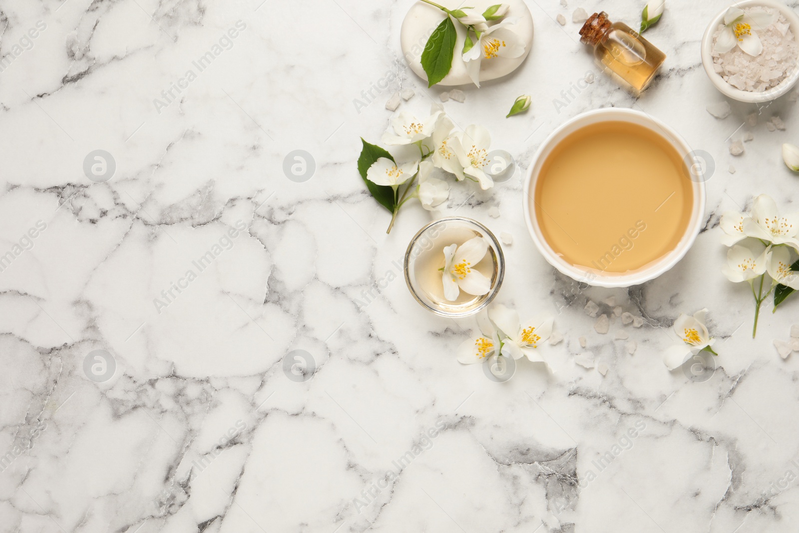 Flat lay composition with jasmine essential oil and fresh flowers on white marble table. Space for text Photo of Flat lay composition with jasmine essential oil and fresh flowers on white marble table. Space for text