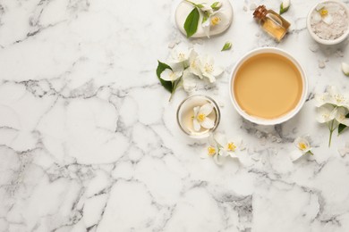 Flat lay composition with jasmine essential oil and fresh flowers on white marble table. Space for text Photo of Flat lay composition with jasmine essential oil and fresh flowers on white marble table. Space for text