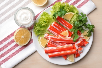 Delicious crab sticks served on wooden table, flat lay Photo of Delicious crab sticks served on wooden table, flat lay