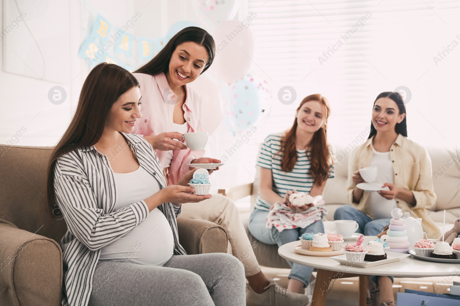 Happy pregnant woman spending time with friends at baby shower party Photo of Happy pregnant woman spending time with friends at baby shower party