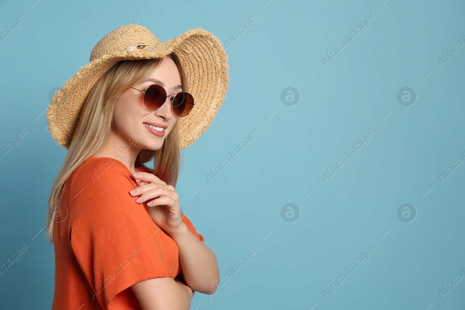 Beautiful young woman wearing straw hat and sunglasses on light blue background, space for text. Stylish headdress Photo of Beautiful young woman wearing straw hat and sunglasses on light blue background, space for text. Stylish headdress