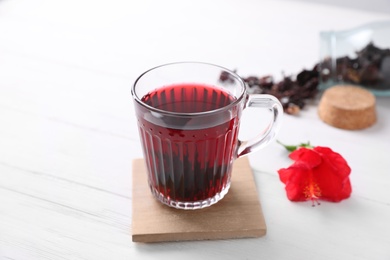 Delicious hibiscus tea on white wooden table Photo of Delicious hibiscus tea on white wooden table