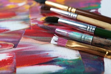 Set of different brushes on abstract colorful paint, closeup Photo of Set of different brushes on abstract colorful paint, closeup