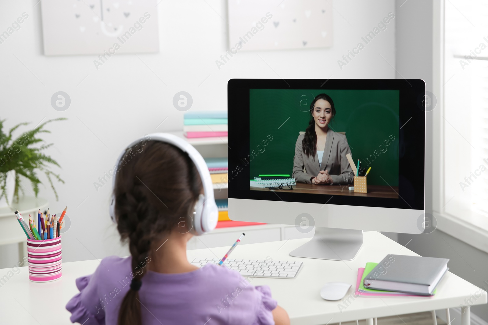 Distance learning, studying at home. Girl having online school lesson with teacher during quarantine and lockdown due to Covid-19 pandemic Photo of Distance learning, studying at home. Girl having online school lesson with teacher during quarantine and lockdown due to Covid-19 pandemic