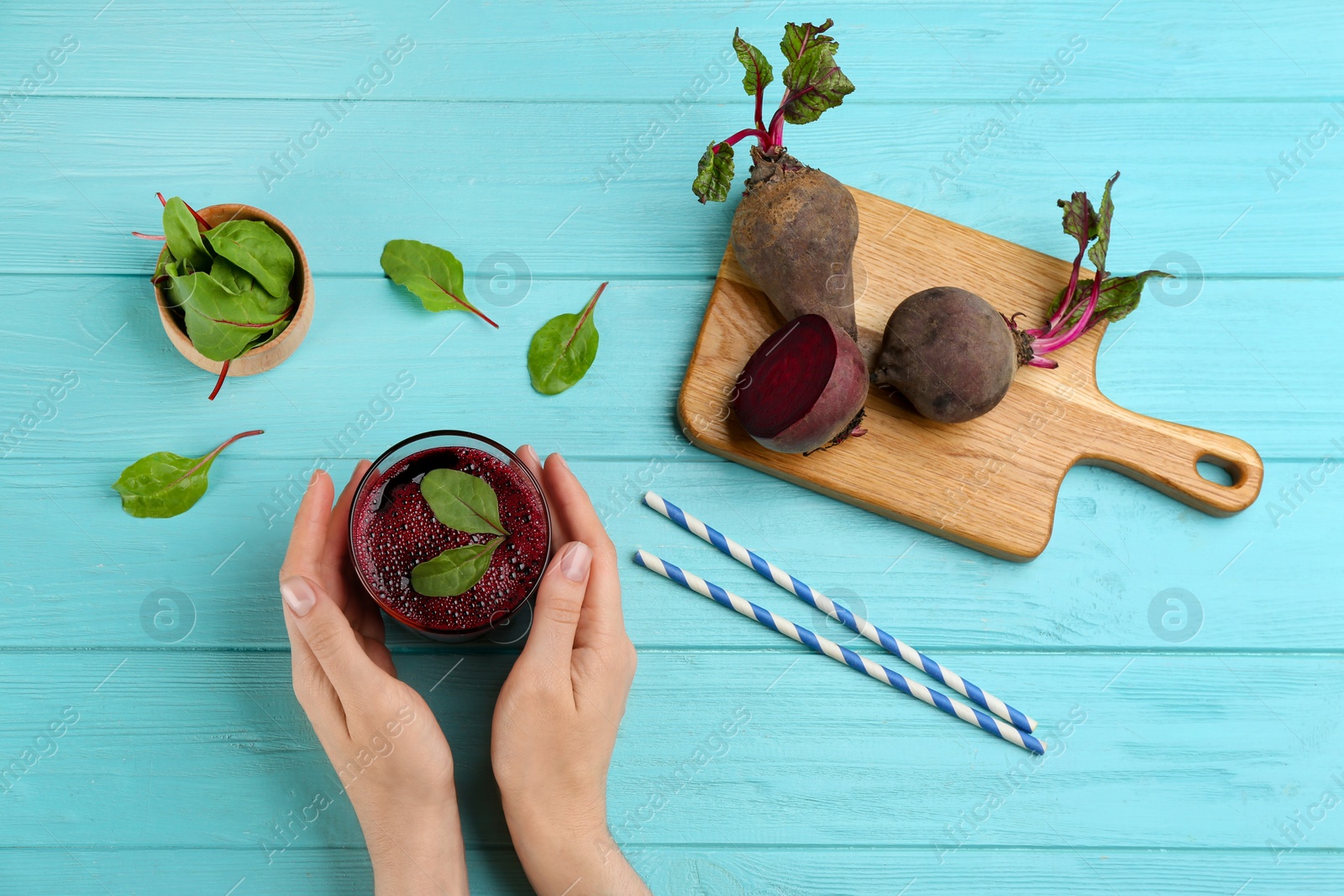 Woman with glass of delicious beet juice at blue wooden table, top view Photo of Woman with glass of delicious beet juice at blue wooden table, top view