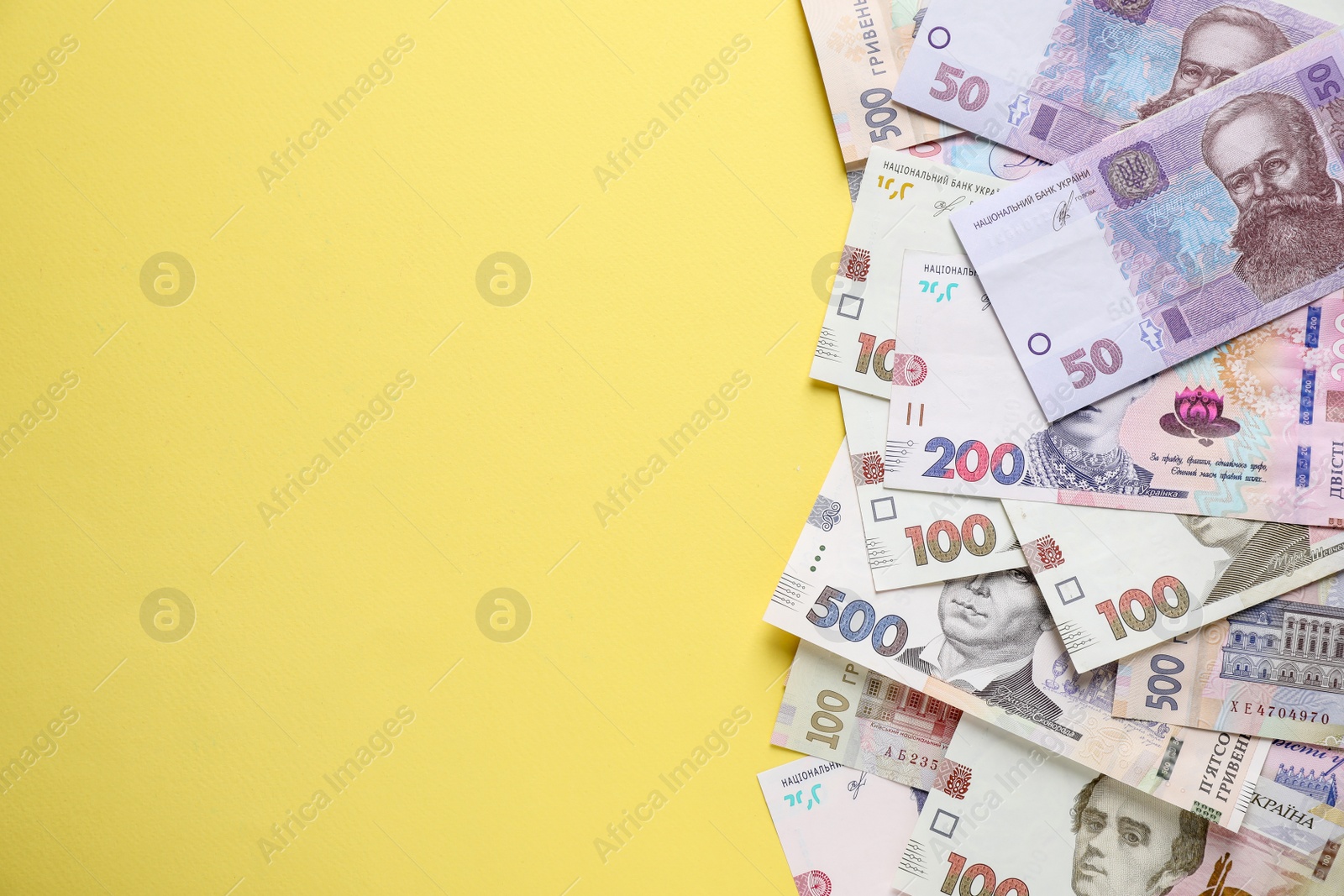 Ukrainian money on yellow background, flat lay. Space for text Photo of Ukrainian money on yellow background, flat lay. Space for text
