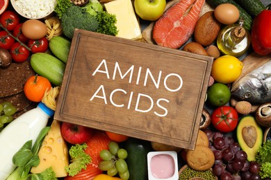 Wooden board with text AMINO ACIDS among different products, top view Image of Wooden board with text AMINO ACIDS among different products, top view