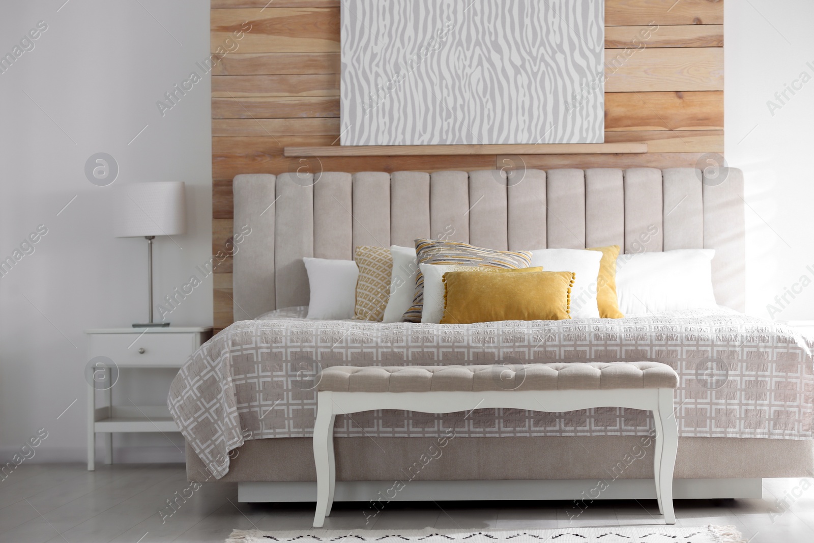 Photo of Comfortable bed with soft color pillows indoors