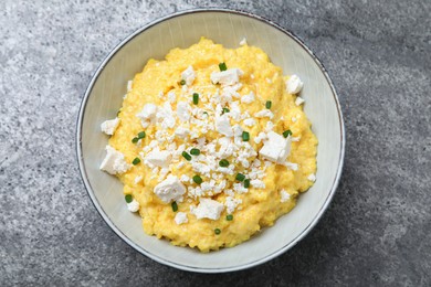 Tasty banosh served with brynza and cut green onions on grey table, top view. Traditional Ukrainian dish Photo of Tasty banosh served with brynza and cut green onions on grey table, top view. Traditional Ukrainian dish