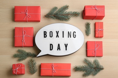 Flat lay composition with Boxing Day sign and Christmas gifts on wooden table Photo of Flat lay composition with Boxing Day sign and Christmas gifts on wooden table