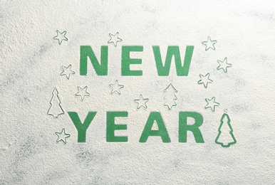 Words NEW YEAR made of flour on green background, top view Photo of Words NEW YEAR made of flour on green background, top view