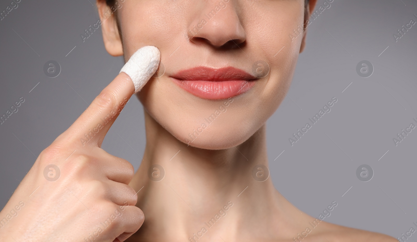 Woman using silkworm cocoon in skin care routine on grey background, closeup Photo of Woman using silkworm cocoon in skin care routine on grey background, closeup