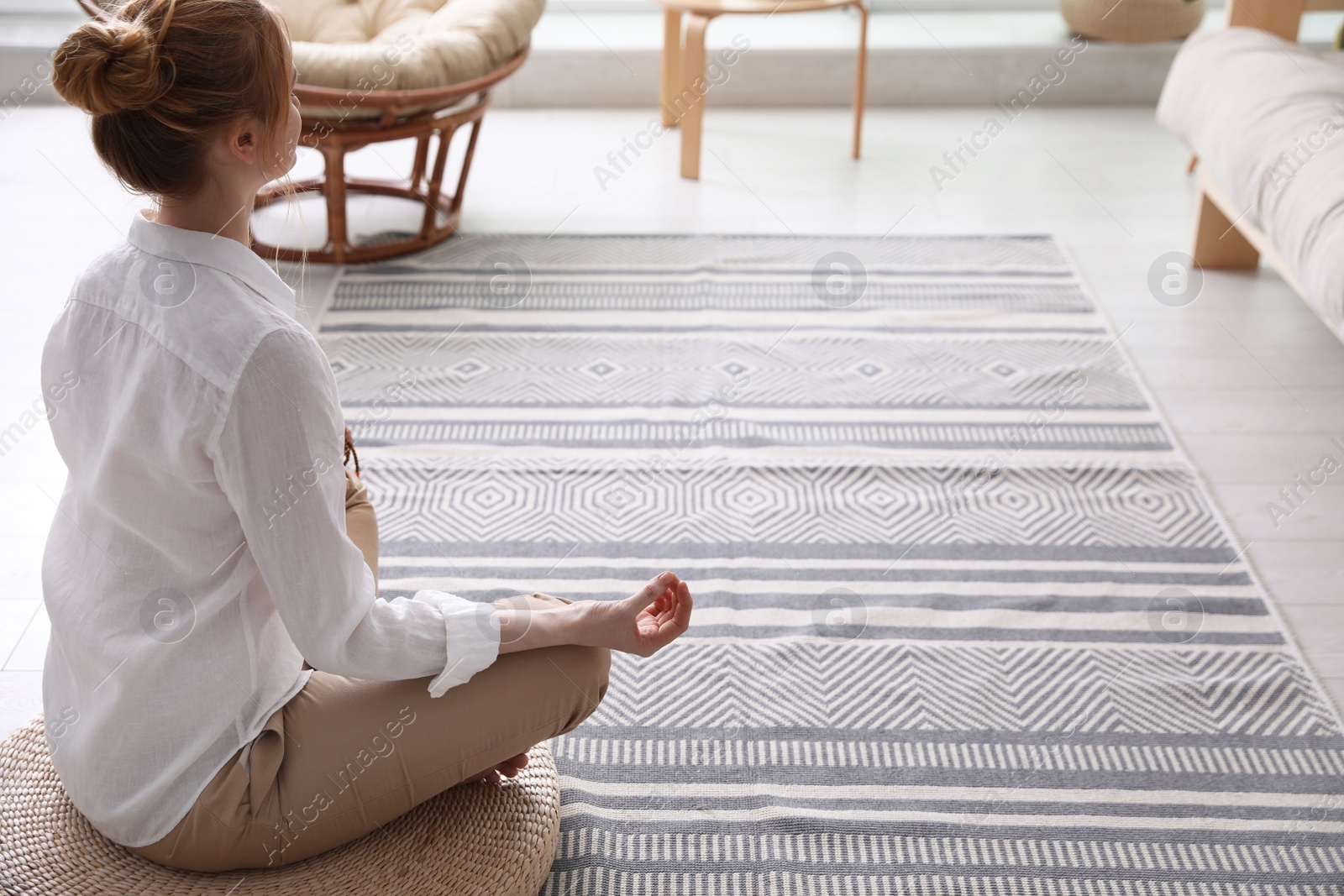 Woman meditating on wicker mat at home. Space for text Photo of Woman meditating on wicker mat at home. Space for text