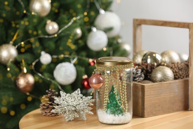 Handmade snow globe and Christmas decorations on wooden table Photo of Handmade snow globe and Christmas decorations on wooden table