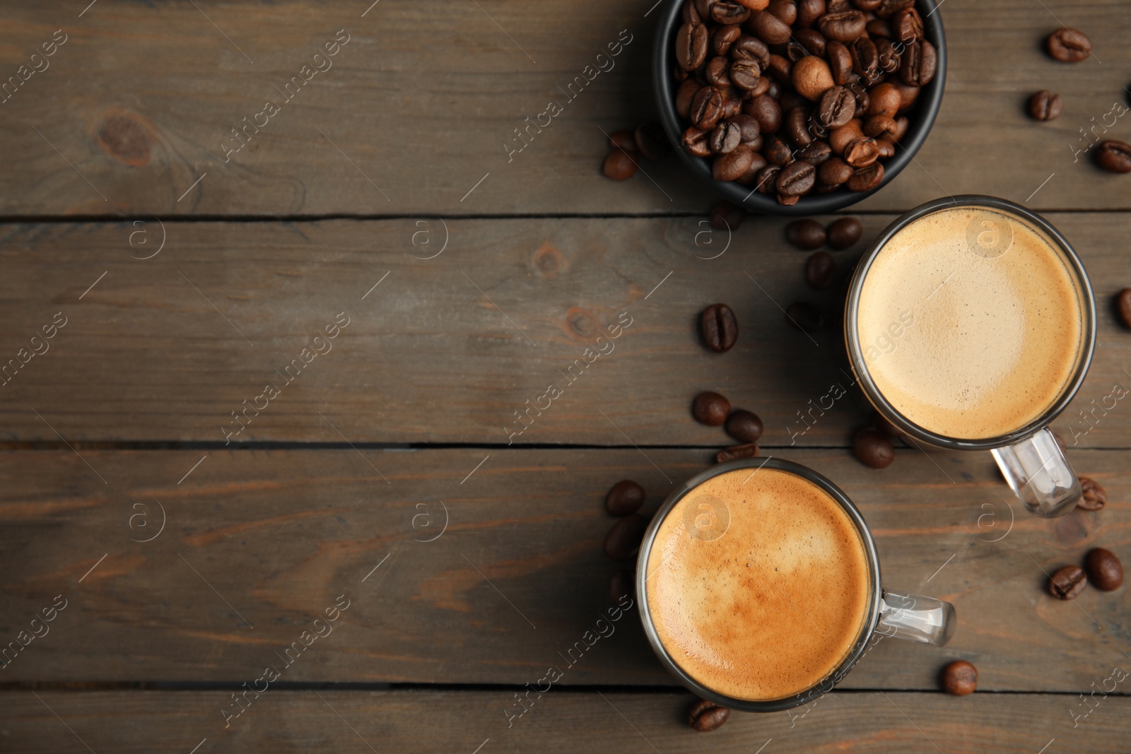 Cups of hot aromatic coffee and roasted beans on wooden table, flat lay. Space for text Photo of Cups of hot aromatic coffee and roasted beans on wooden table, flat lay. Space for text