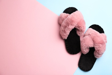 Pair of soft slippers on color background, flat lay. Space for text Photo of Pair of soft slippers on color background, flat lay. Space for text