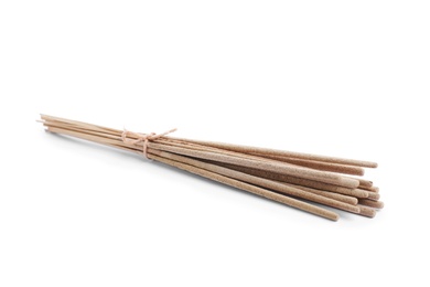 Photo of Many aromatic incense sticks tied with twine on white background