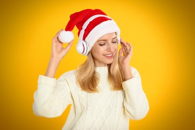 Happy woman with headphones on yellow background. Christmas music Photo of Happy woman with headphones on yellow background. Christmas music